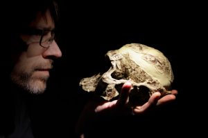 Teacher with an Australopithecus africanus skull model on his hand.