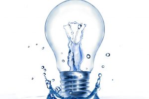 Light bulb with water and splash isolated on white